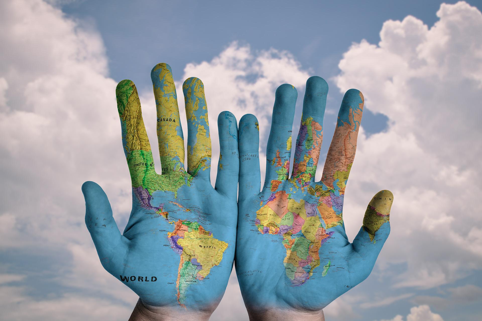 Two open hands with a map of the world
